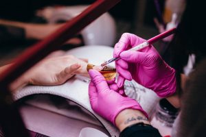 A nail technician doing an artificial nail for a customer - Darren Yaw Cambodia