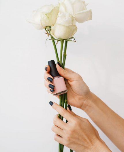 woman-holds-nail-varnish-and-flowers-beauty-salon-U2366SW.jpg